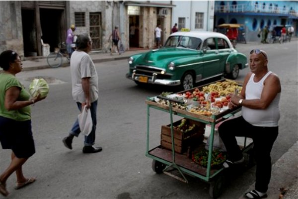 Un vendedor de frutas y vegetales aguarda la llegada de clientes en una calle de La Habana, Cuba, el martes 3 de diciembre de 2013. Algunos cubanos han aprovechado las incipientes facilidades autorizadas por el gobierno para iniciar pequeños negocios. (Foto AP/Franklin Reyes)